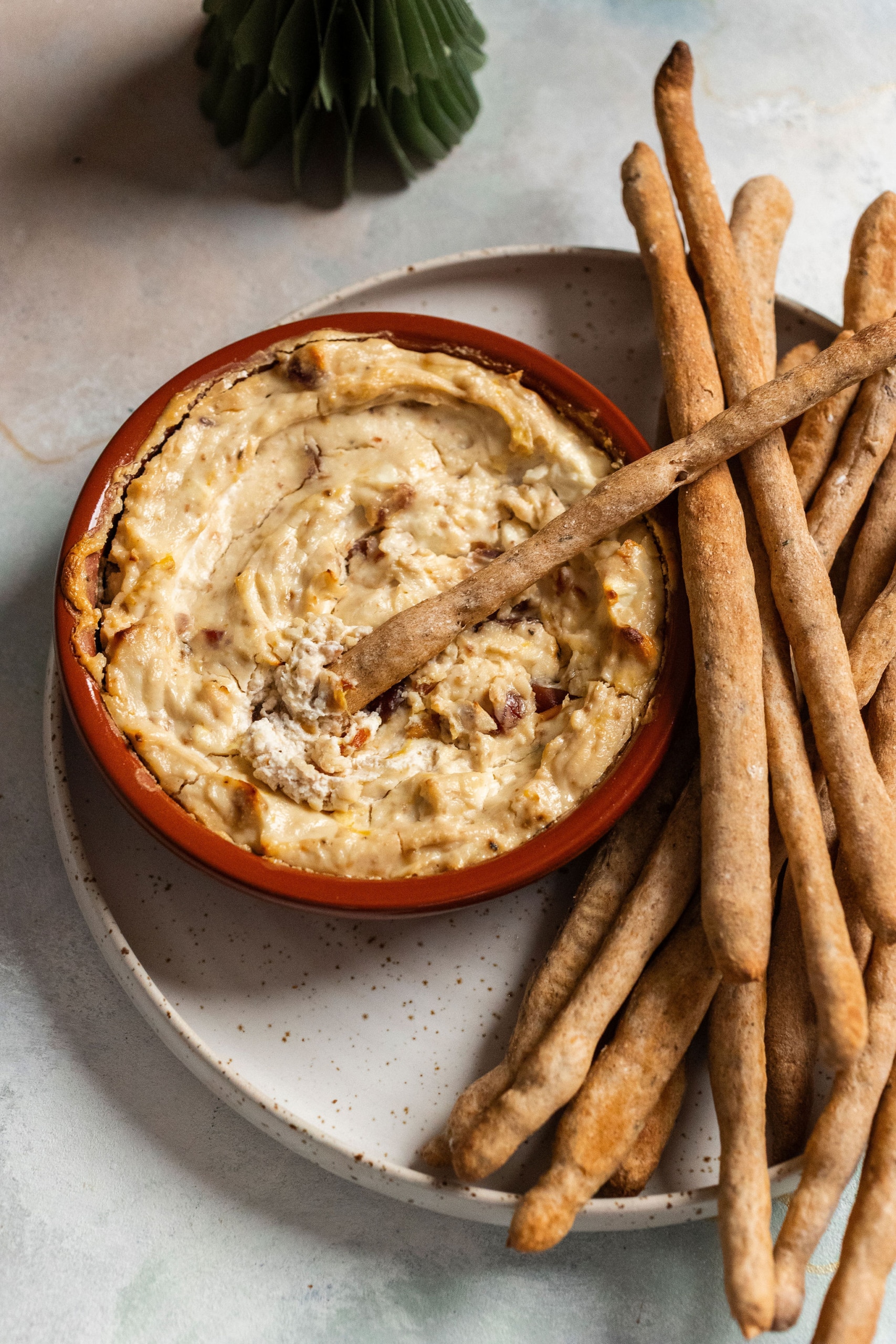 Pikáns kecskesajtkrém datolyával, mézzel és chilivel, magos, zöldfűszeres grissinivel.